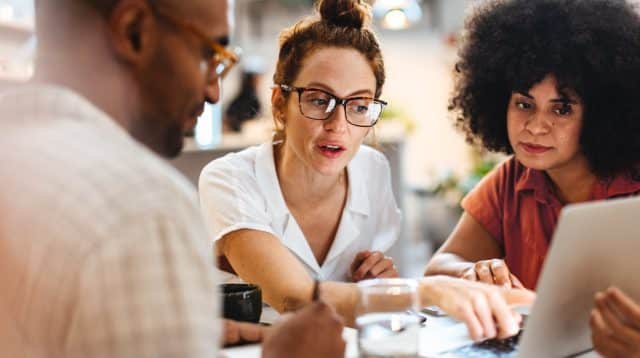 gelukkige medewerkers achter een computer, betrokkenheid en tevredenheid