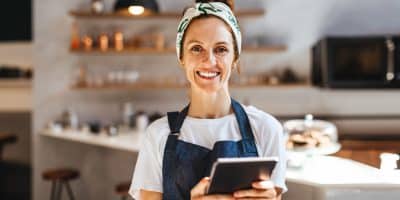 Café-eigenaresse die op een tablet haar zaken regelt