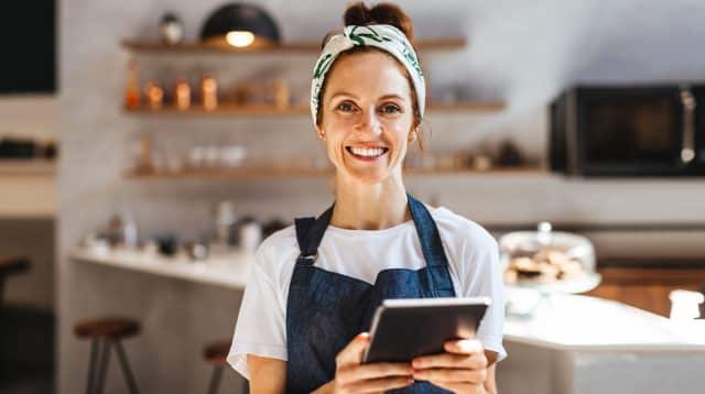 Café-eigenaresse die op een tablet haar zaken regelt