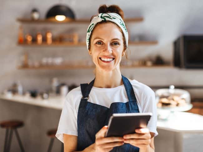 Café-eigenaresse die op een tablet haar zaken regelt