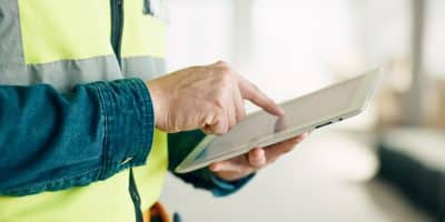 Medewerker in de bouw die een tablet in zijn hand heeft